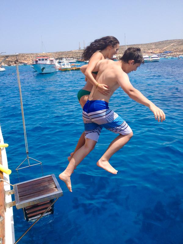 Zwei Teilnehmer der Sprachreise Schüler Malta springen gemeinsam von einem Boot ins Wasser