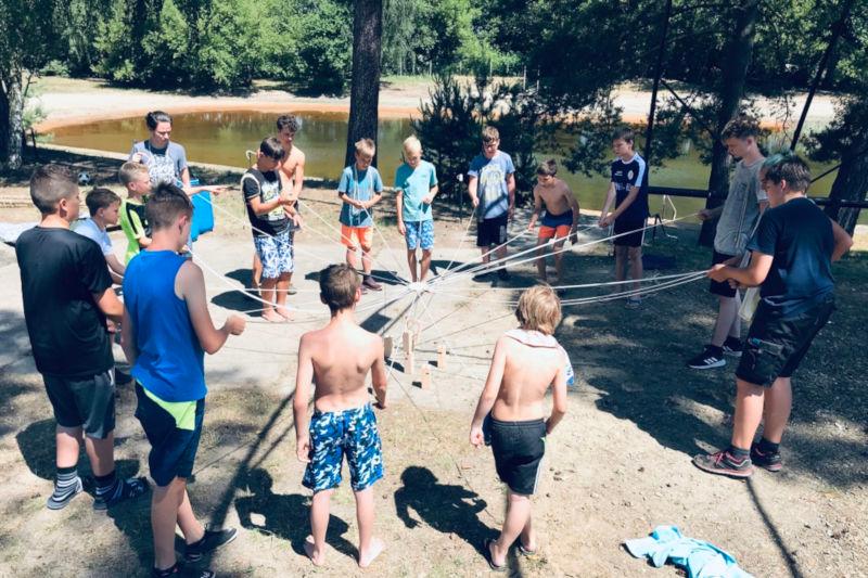 Kinder der Ferienbetreuung Sommerferien spielen Teamspiele
