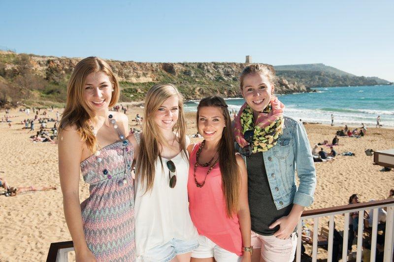 Vier Mädchen posen für die Kamera am Strand bei der Sprachreise Malta St. Julians