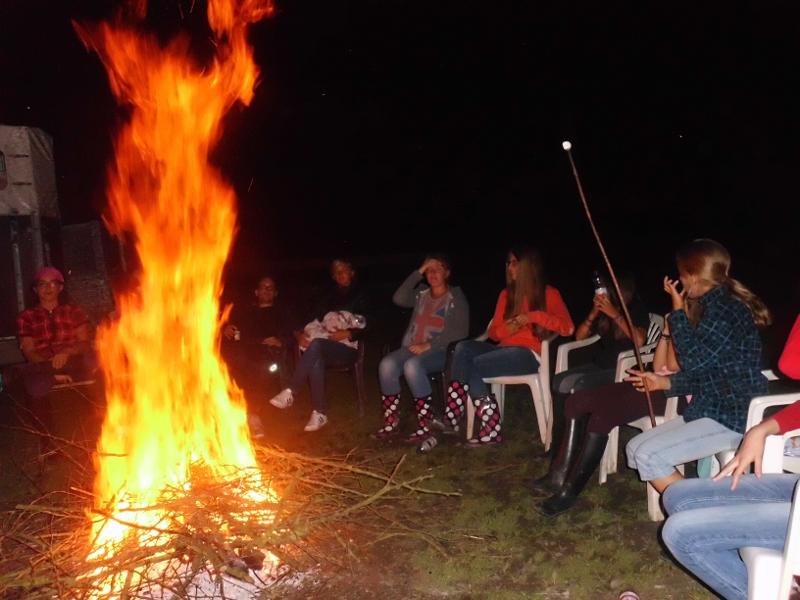 Kinder der Ferienbetreuung NRW sitzen am Feuer