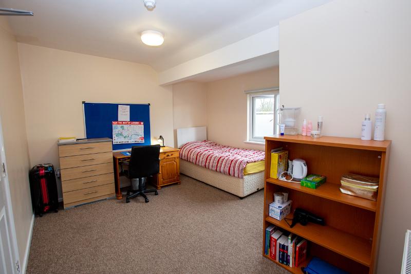 Ein einfaches Studentenzimmer auf Cambridge Sprachreise verfügt über ein Bett und einen Schreibtisch