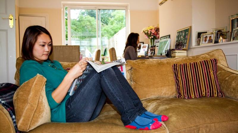 Eine Teilnehmerin der Sprachreise Cambridge sitzt auf der Couch und liest