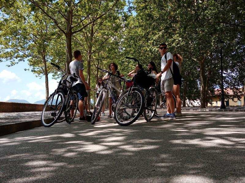 Teilnehmer der Sprachferien Italien stehen neben ihren Fahrrädern auf der Straße