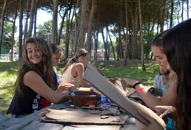 Ein paar Freundinnen basteln auf Italien Sprachreise etwas aus Pappe