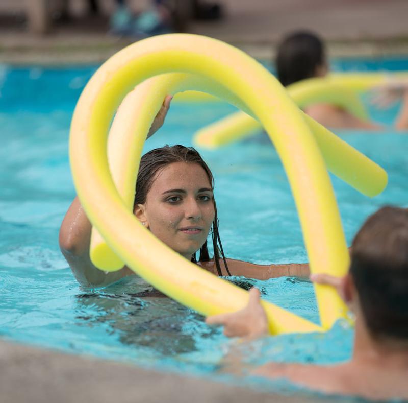 Ein Mädchen steht auf Sprachreise Schottland im Pool mit einer Schwimmnudel