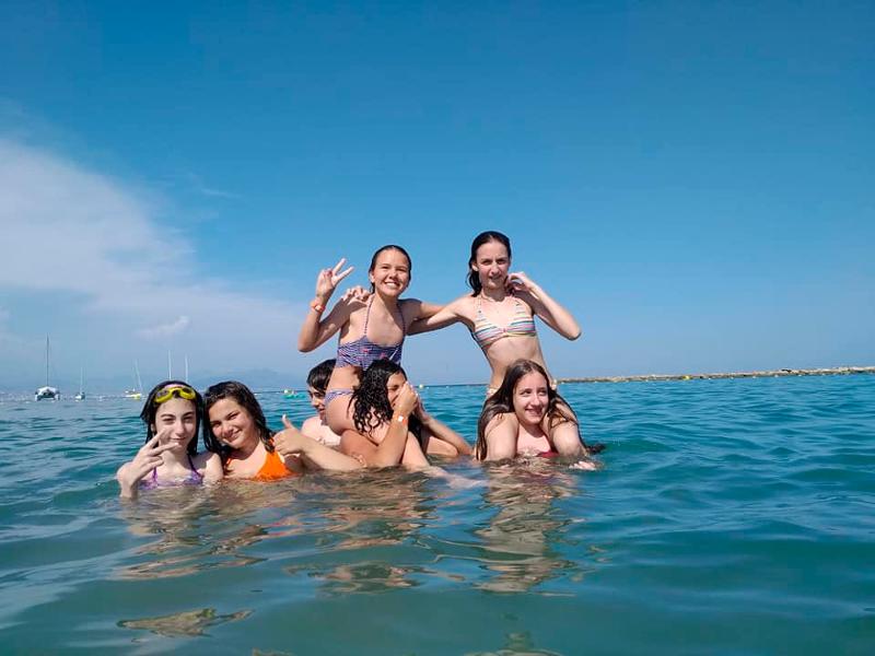 Eine Gruppe von Mädchen hat im Sprachcamp Frankreich beim Schwimmen im Meer Spaß
