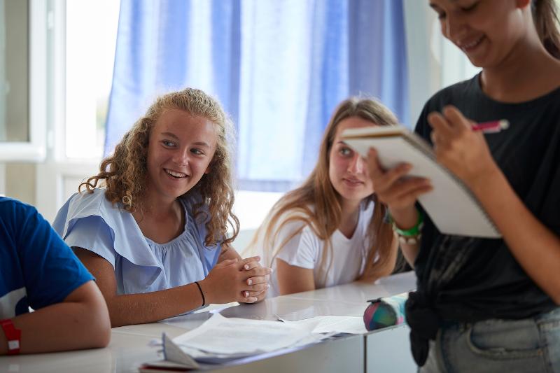 Eine Schülerin sitzt im Klassenraum auf Sprachreise Frankreich und schaut ihren Nachbarn an