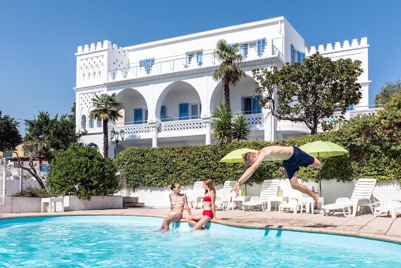 Ein Junge springt auf Sprachreise Frankreich Gastfamilie in den Pool der Unterkunft