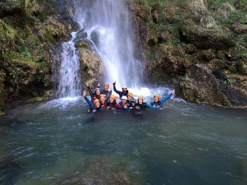 Eine Gruppe Jugendlicher badet bei einem Wasserfall bei den Sprachreisen Spanisch Last Minute