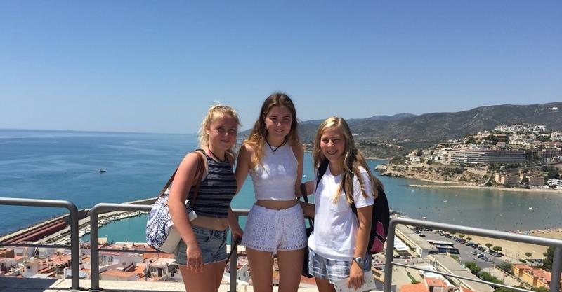 Drei Mädchen stehen bei einer Jugendreise nach Spanien vor einem Aussichtspunkt