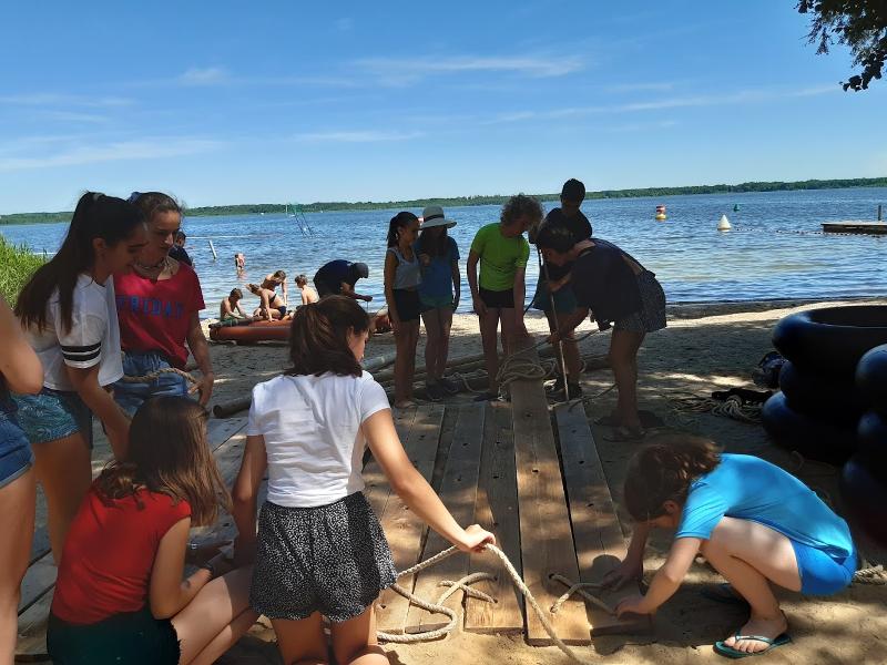 Die Teilnehmer der Sprachreise bauen am See ein Floss