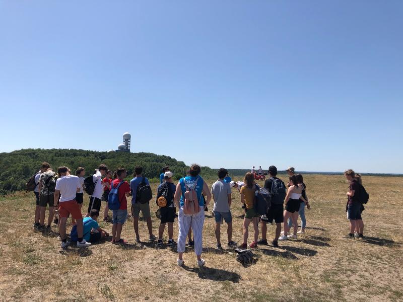 Die Teilnehmer der Sprachreise stehen mit Rucksäcken auf einem Berg