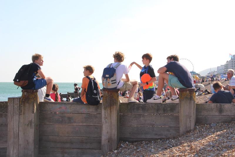 Teilnehmer der Sprachreise England Kinder sitzen auf einem Steg am Strand