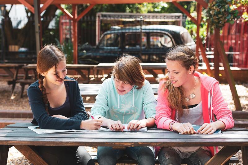 Auf Sprachreise England lernen die Teenager gemeinsam draußen an einem Tisch