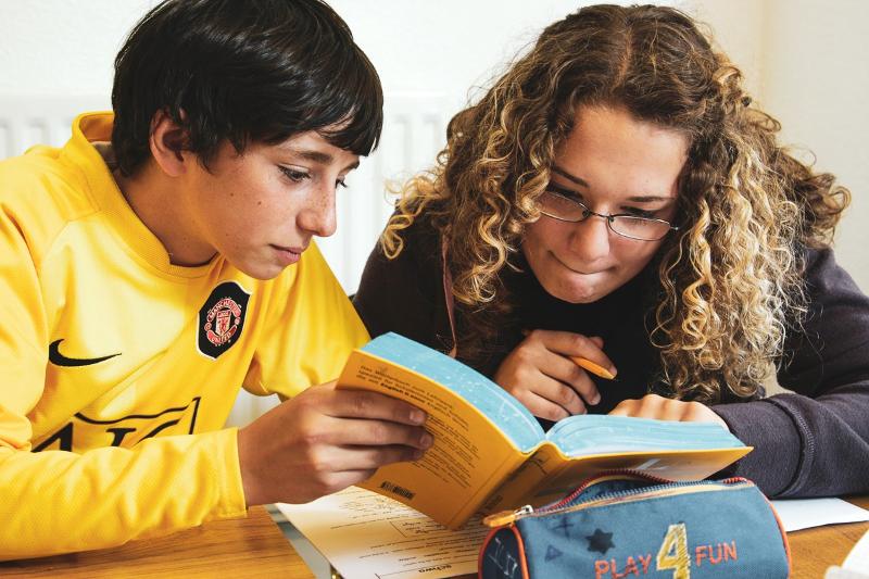Zwei Schüler studieren auf Englisch Sprachreise ein Wörterbuch