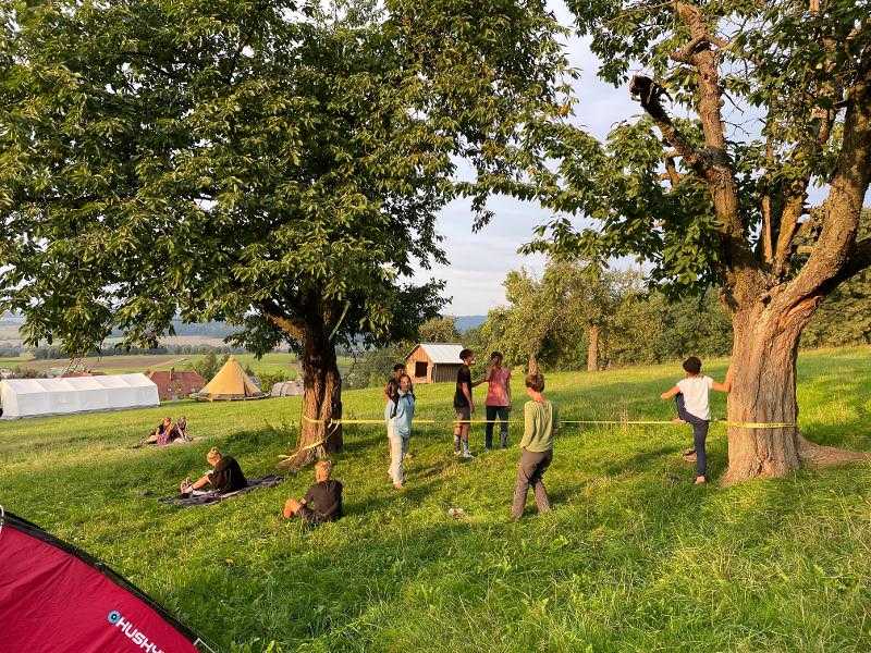 Kinder der Ferienbetreuung slacklinen