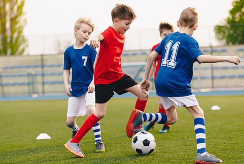  Jungs dribbeln im Fußballtagescamp.