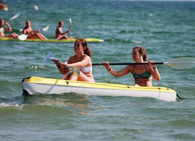 zwei Mädchen fahren mit dem Kanu über das Wasser