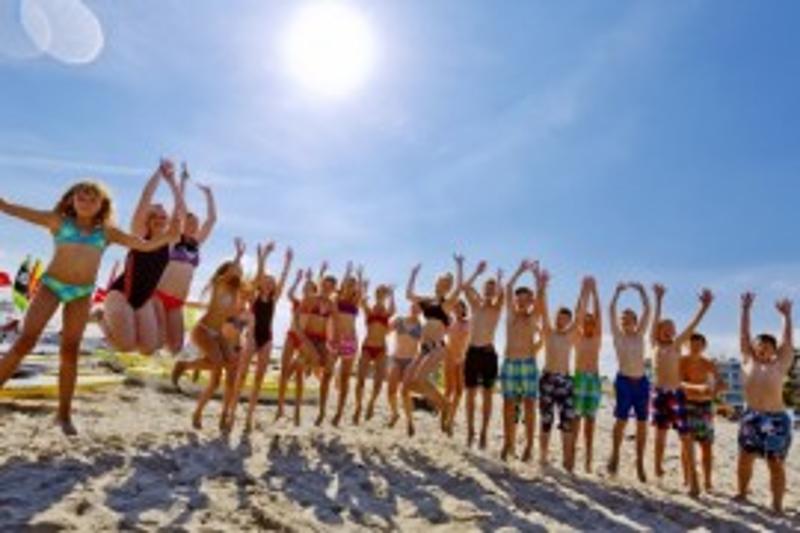 Gruppe Jugendliche springt am Strand auf der Jugendreise Ostsee