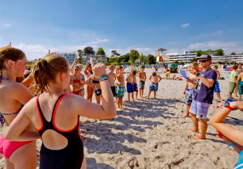 Jugendliche spielen am Strand ein Spiel auf der Jugendreise Ostsee
