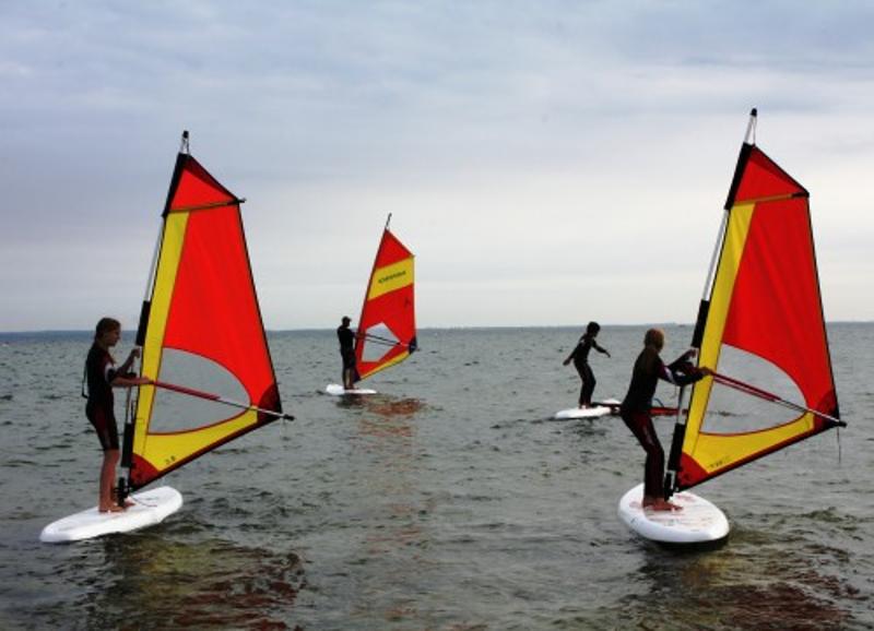 Gruppe steht auf Surfbrettern auf dem Wasser im Ostsee Jugendurlaub