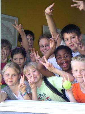 Teilnehmer eines Englisch Camps Berlin zeigen Peace und jubeln