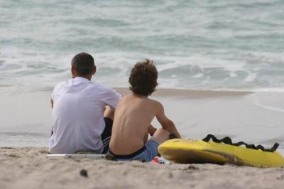 Kinder eines Herbstcamps sitzen am Meer