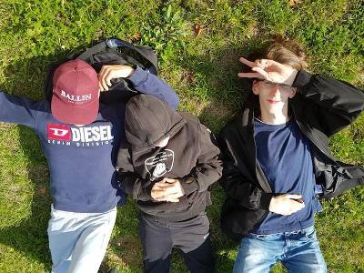 Drei Jungs chillen im Gras auf der Ferienfreizeit in Belgien