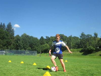 Junge beim Slalom im Fußballcamp Bayern