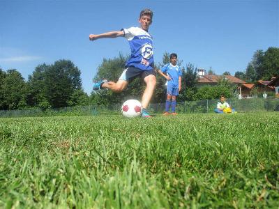Junge schießt Ball im Fußballcamp Deutschland