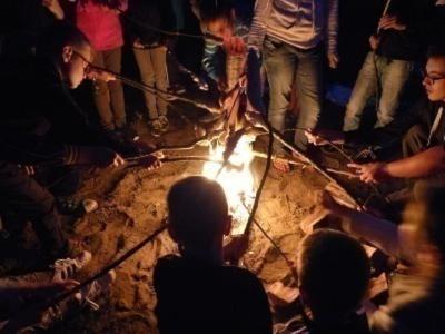 Kinder rösten Stockbrot über dem Feuer im Ferienlager in Mecklenburg-Vorpommern