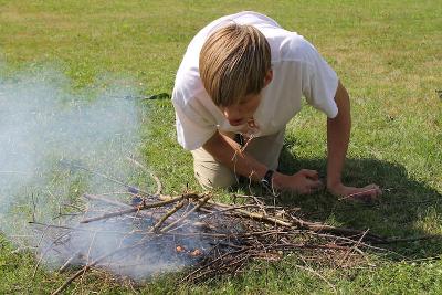 Junge macht ein Feuer im Herbstcamp Johanngeorgenstadt