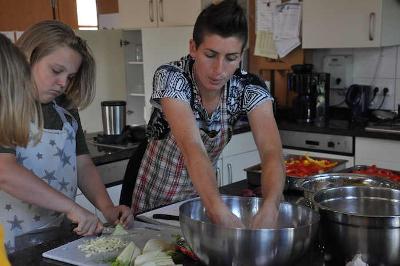 Betreuerin und Jugendlicher kochen im Kreativcamp