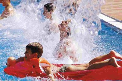Kinder spielen bei sommerlichem Wetter im Pool des Jugendhotels Club Kitzsteinhorn in Zell am See
