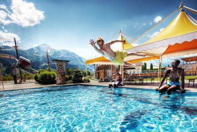 Jugendliche erfrischen sich bei sommerlichem Wetter im Pool des Jugendhotels Club Kitzsteinhorn in Zell am See