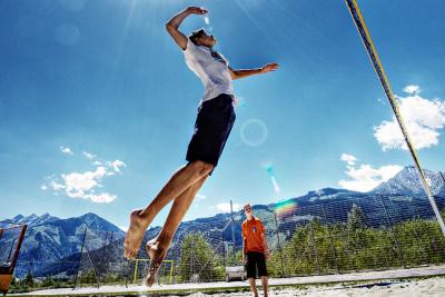 Jugendliche auf dem Beachvolleyballfeld im Außenbereich des Jugendhotels Club Kitzsteinhorn in Zell am See