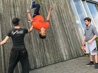 Ein Junge eines Abenteuer-Forschercamps macht einen Salto