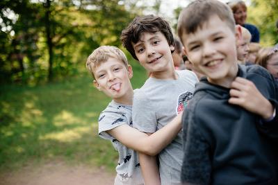 Teilnehmer eines Kindersprachkurses Englisch umarmen sich
