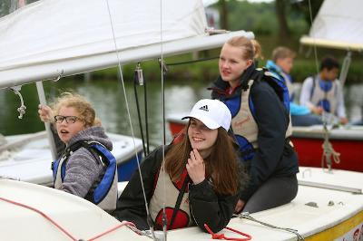 Teilnehmer der Englisch-Ferien sitzen auf dem Segelboot