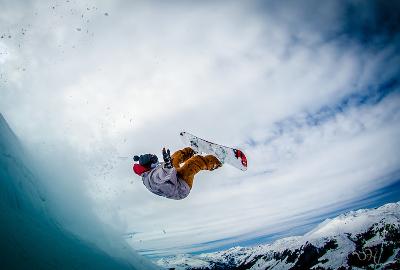 Snowboardfahrer macht einen Salto auf der Skifreizeit Österreich