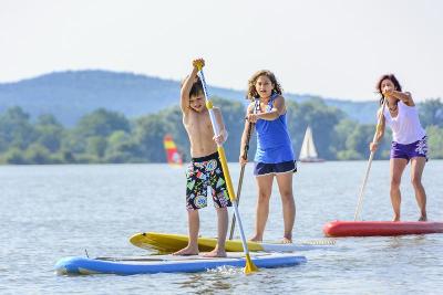 Kinder eines Sportcamps rudern