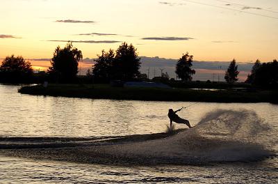 Im Sonnenuntergang fährt ein Teilnehmer eines Wakeboard Camps Wakeboard