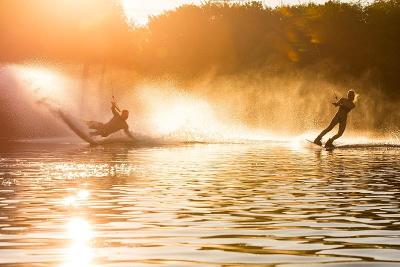 Zwei Teilnehmer eines Ferienlagers Sachsen fahren im Abendrot Wakeboard