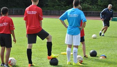 Die Jungs stehen im Fußballcamp in einer Schlange und warten auf ihren Einsatz