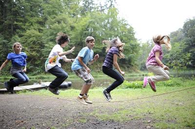 Kinder einer Osterfreizeit springen Seil