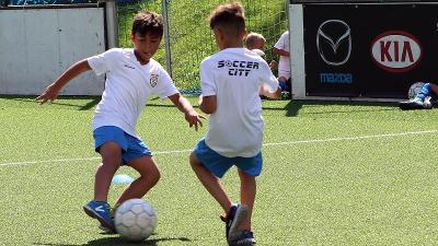 Zwei Jungs einer Fußball-Schule Ferien kämpfen um den Ball