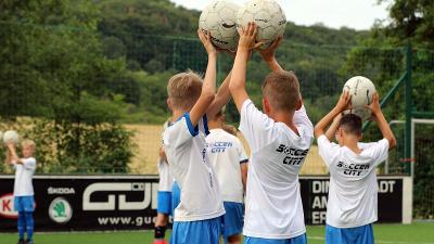 Ein Junge einer Fußball-Schule Ferien versucht einen Ball zu fangen