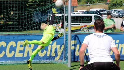 Ein Torwart einer Fußball-Schule Ferien springt zum Ball