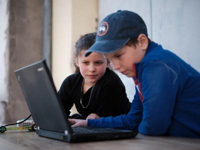 Zwei Teilnehmer sitzen im Programmier-Camp gemeinsam vor dem Laptop