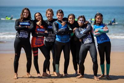 Eine Gruppe von Jugendlichen Surfern steht im Portugal Surfcamp am Strand